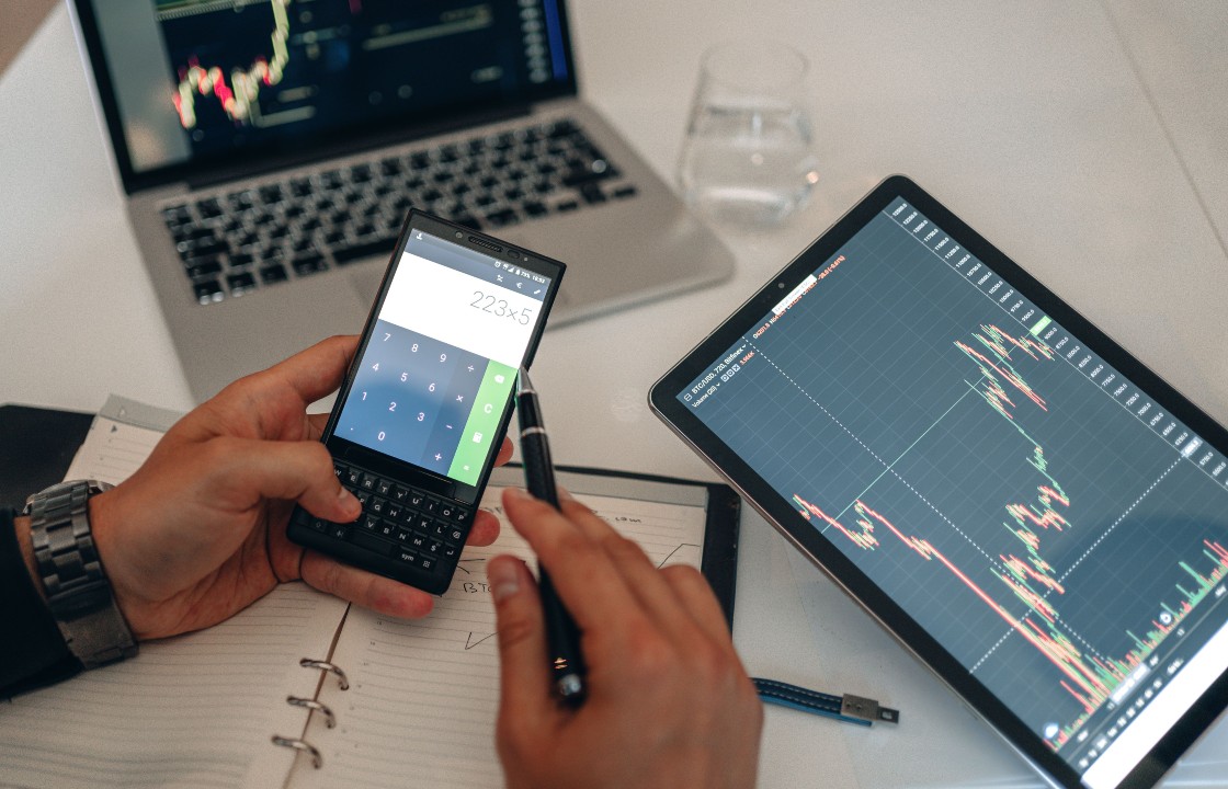 calculator and laptop with graphs demonstrating business growth